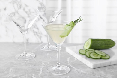 Photo of Glass of tasty cucumber martini on grey marble table