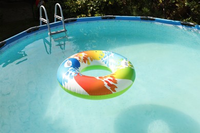 Photo of Inflatable ring floating on water in above ground swimming pool outdoors