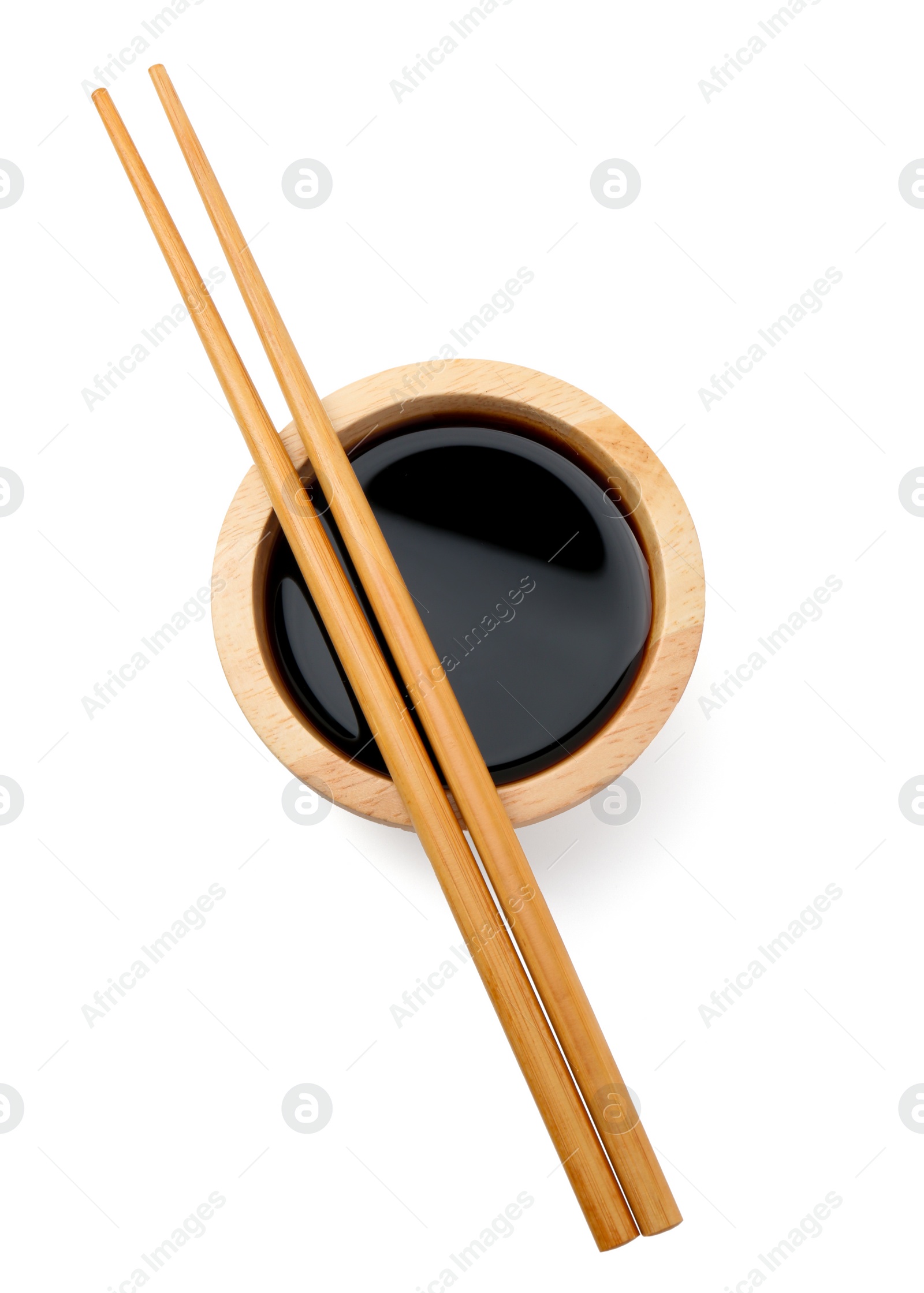 Photo of Tasty soy sauce in bowl and chopsticks isolated on white, top view