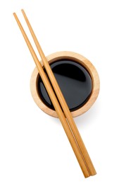 Photo of Tasty soy sauce in bowl and chopsticks isolated on white, top view