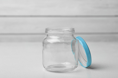 Photo of Open empty glass jar on white table