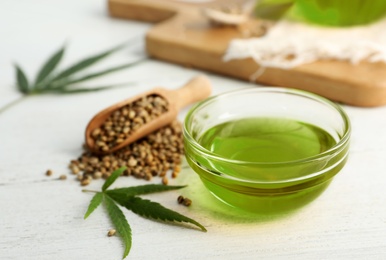 Photo of Composition with hemp oil on white wooden table