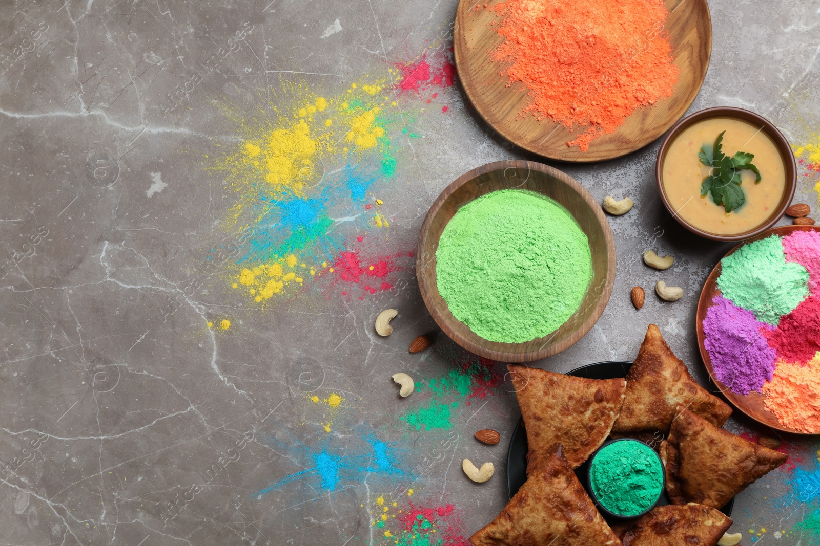 Photo of Traditional Indian food and color powders on grey table, flat lay with space for text. Holi festival celebration