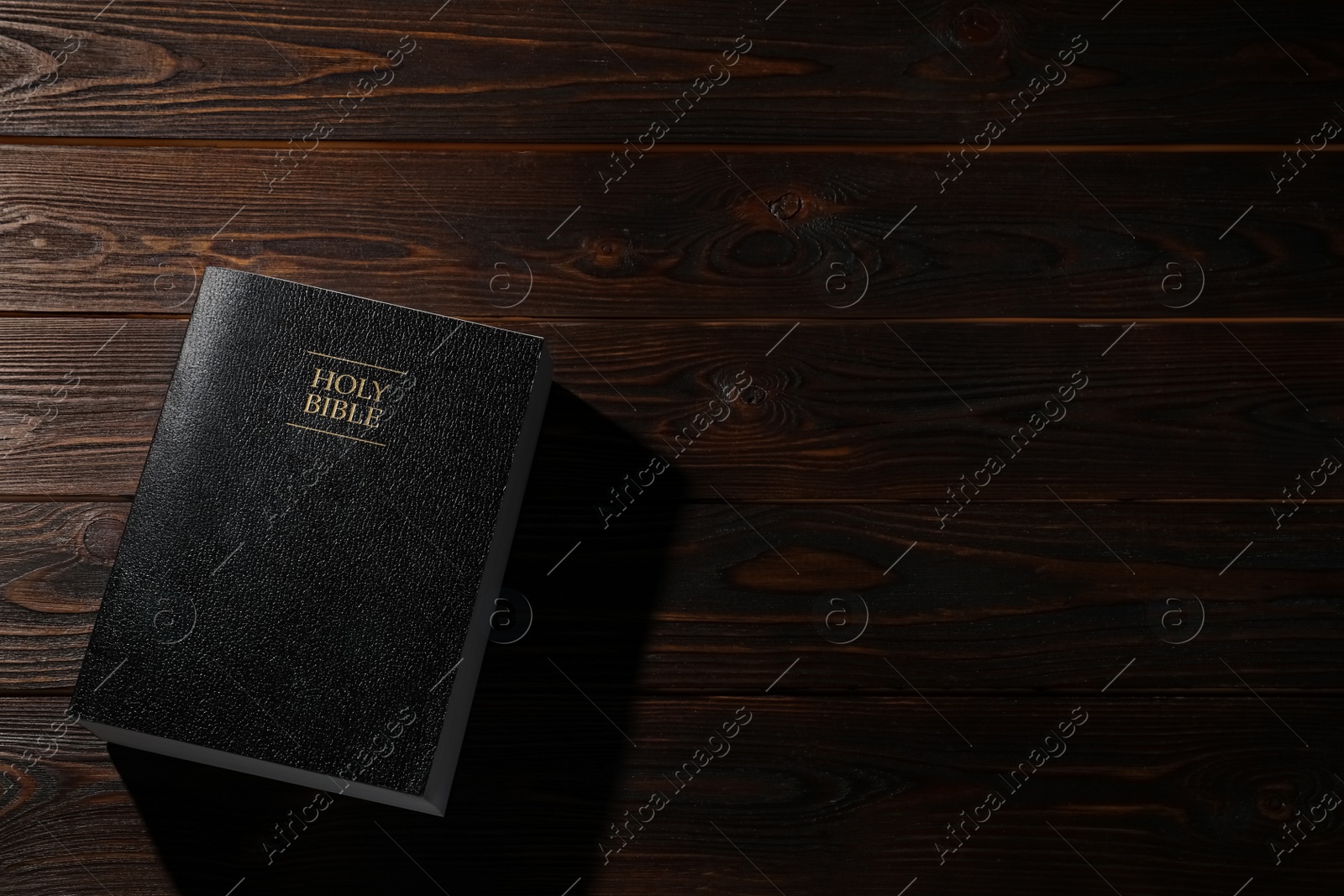Photo of Bible on wooden table, top view with space for text. Christian religious book