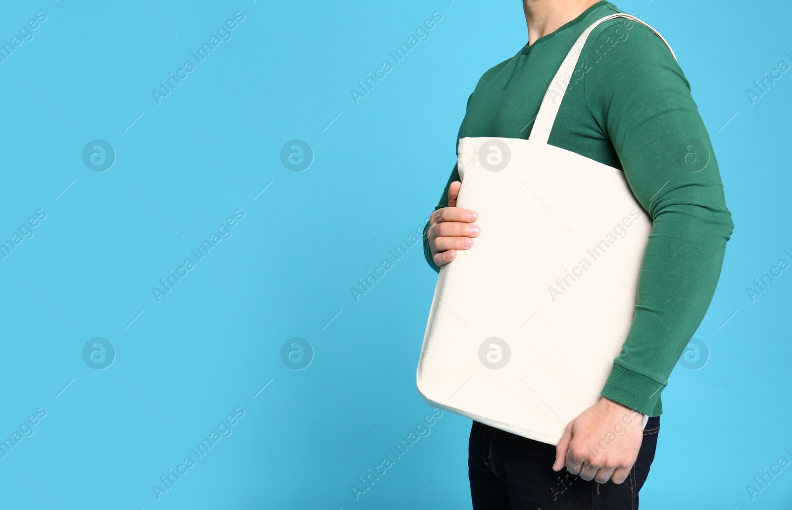 Photo of Young man with eco bag on blue background, closeup. Space for text