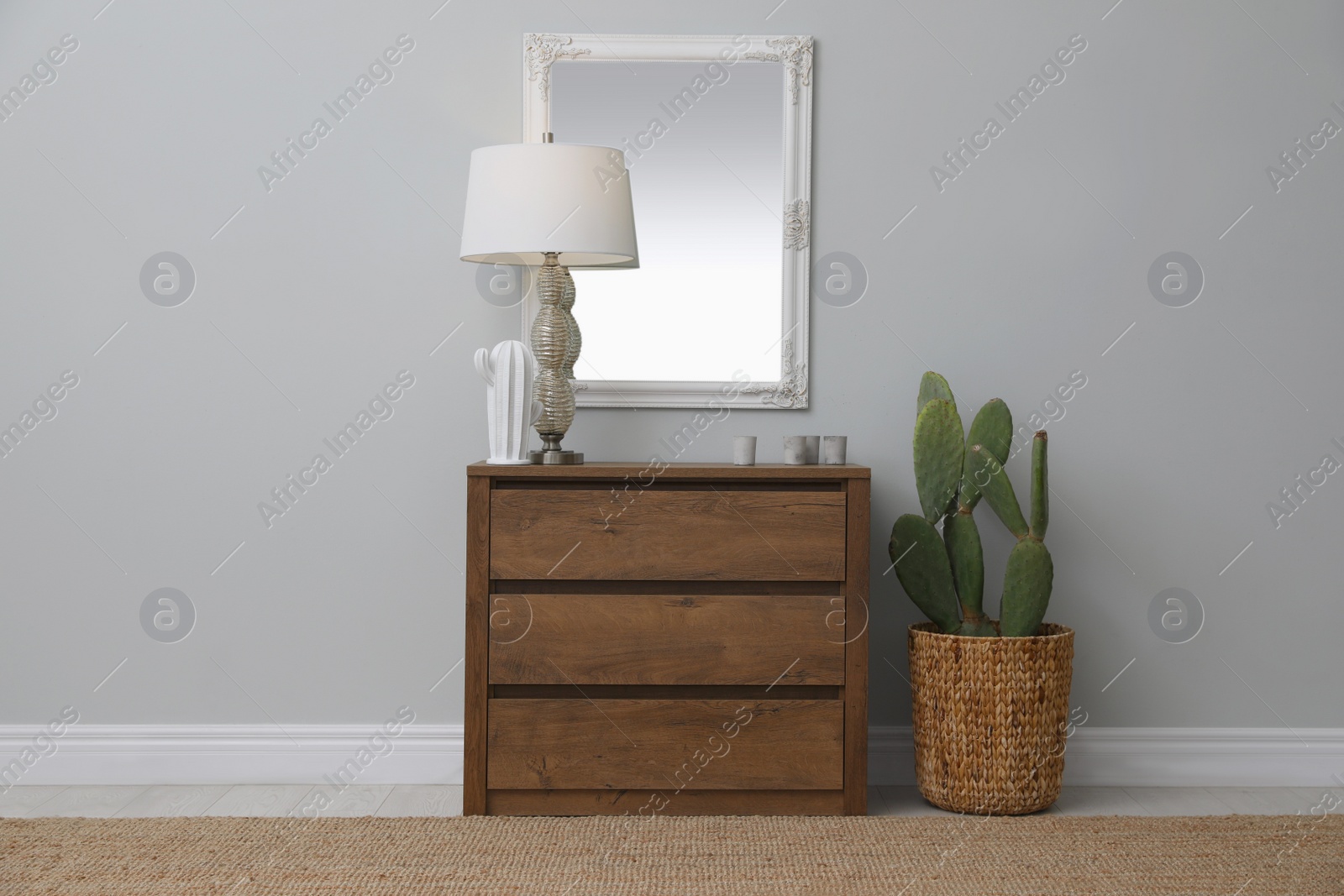 Photo of Light hallway with stylish mirror and chest of drawers. Interior design