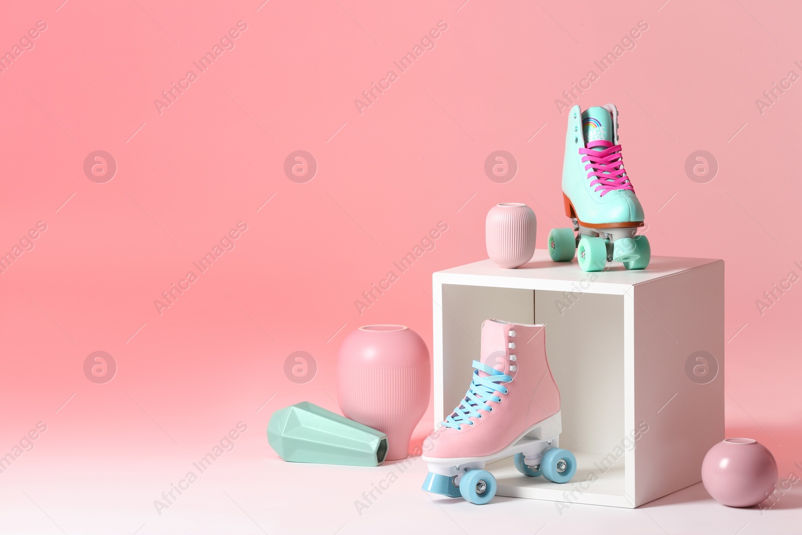 Photo of Composition with vintage roller skates and storage cube on color background. Space for text