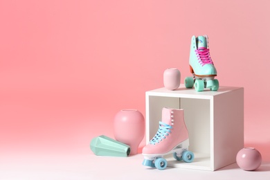 Photo of Composition with vintage roller skates and storage cube on color background. Space for text