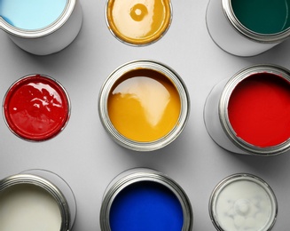 Photo of Open paint cans on grey background, top view