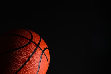 Photo of One basketball ball on black background. Space for text