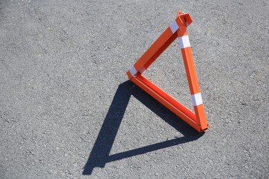 Photo of Triangular parking barrier on asphalt outdoors. Space for text