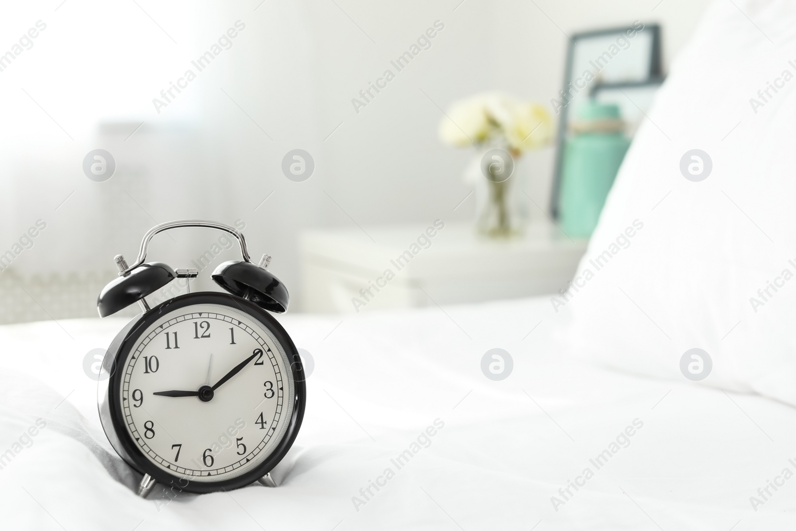 Photo of Alarm clock on bed. Time to wake up