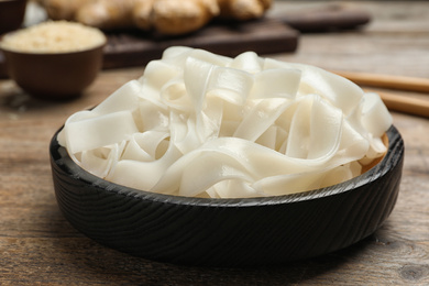 Photo of Tasty rice noodles on wooden table, closeup