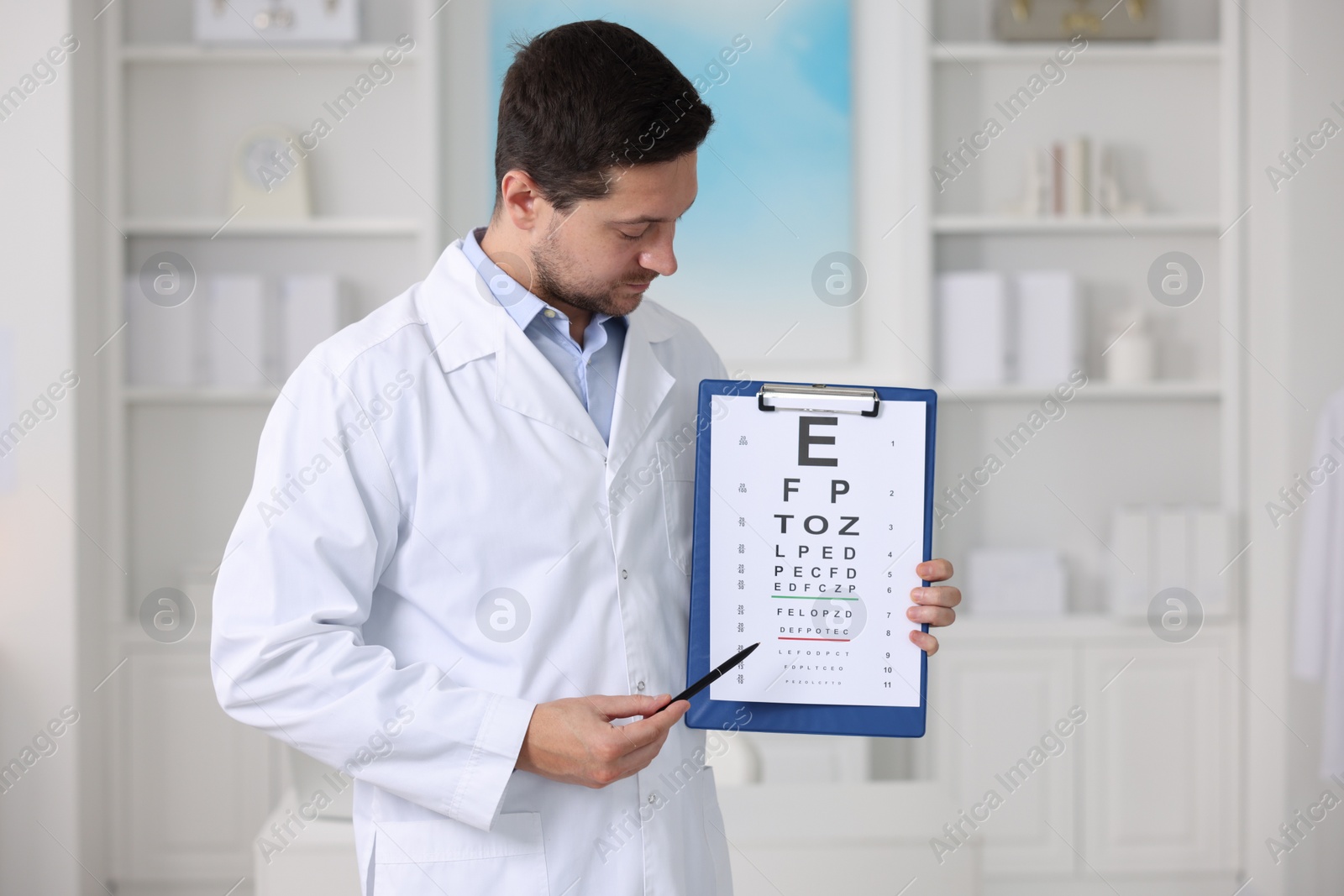 Photo of Ophthalmologist pointing at vision test chart in clinic