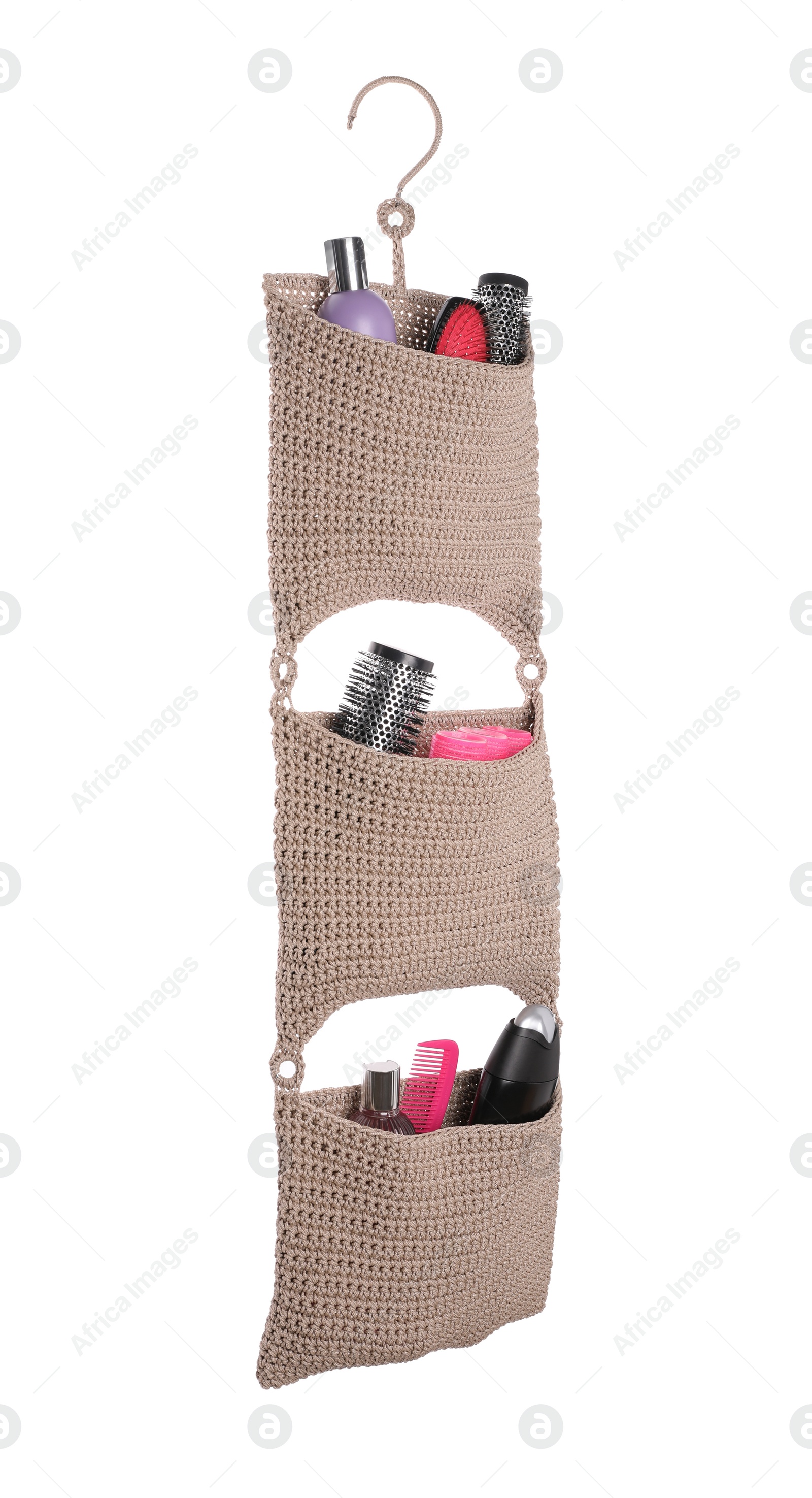 Photo of Stylish knitted organizer with toiletries and hair brushes on white background. Bath accessory