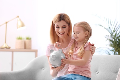 Family with piggy bank and money at home