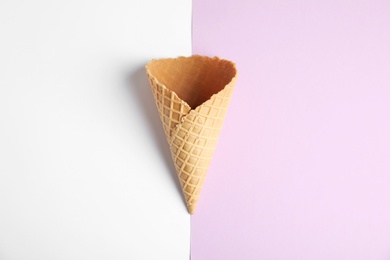 Photo of Empty wafer ice cream cone on color background, top view