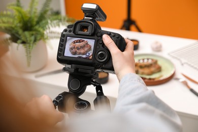 Photo of Food stylist taking photo of delicious meat medallion in studio, closeup