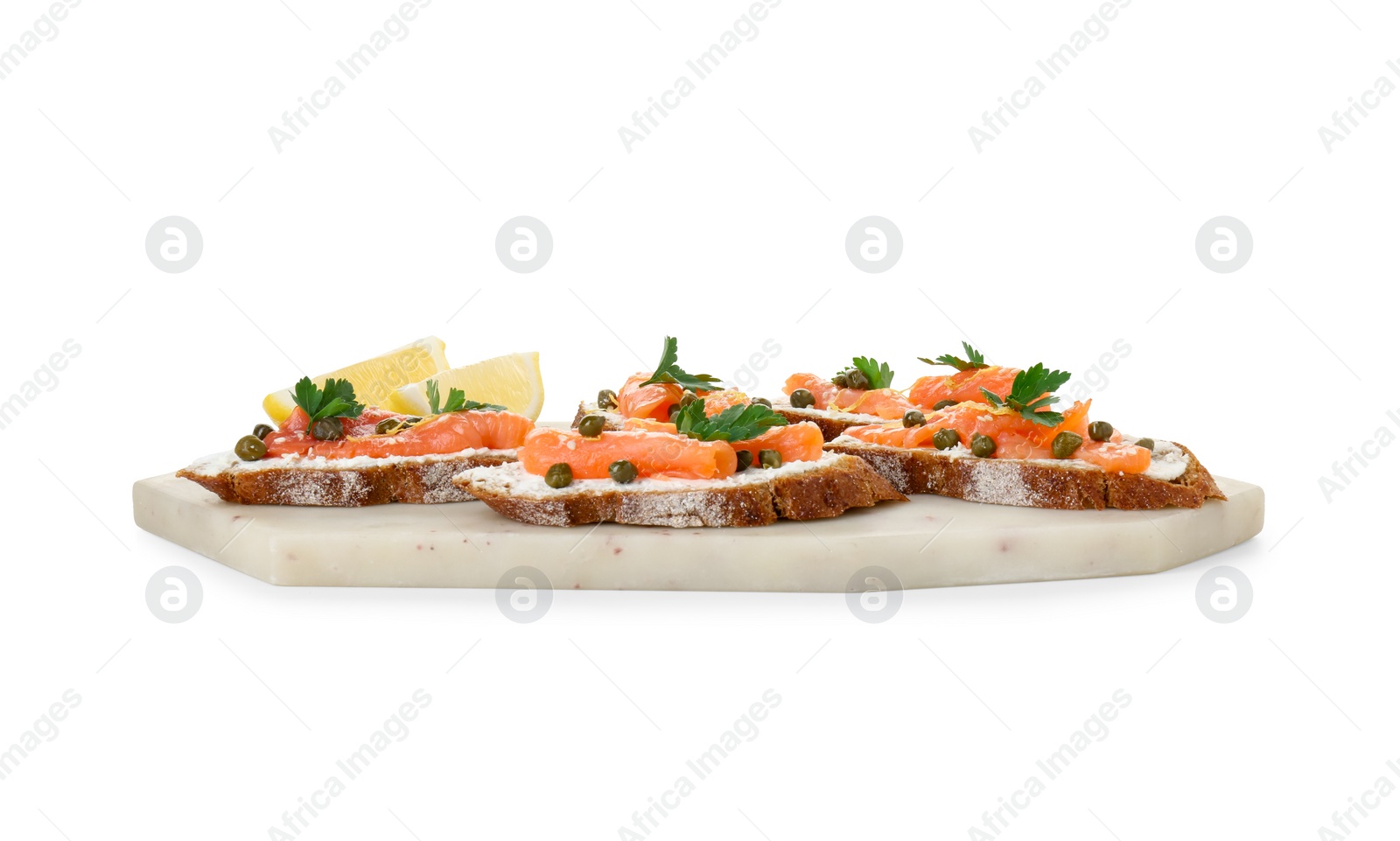 Photo of Tasty canapes with salmon, capers, lemon and cream cheese isolated on white