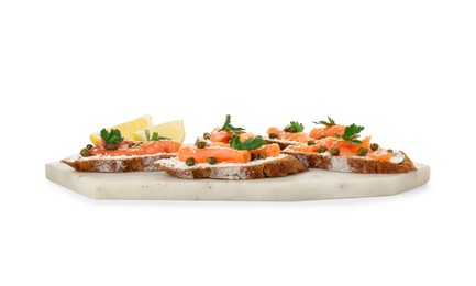 Photo of Tasty canapes with salmon, capers, lemon and cream cheese isolated on white