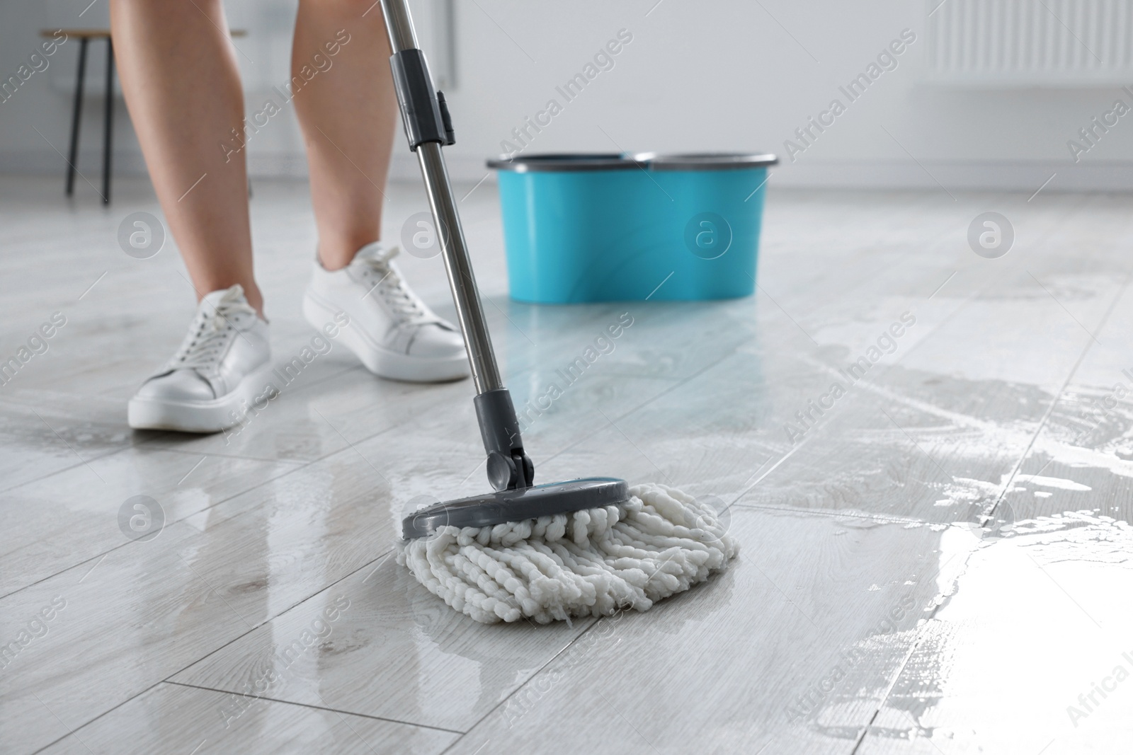 Photo of Woman cleaning floor with mop indoors, closeup. Space for text