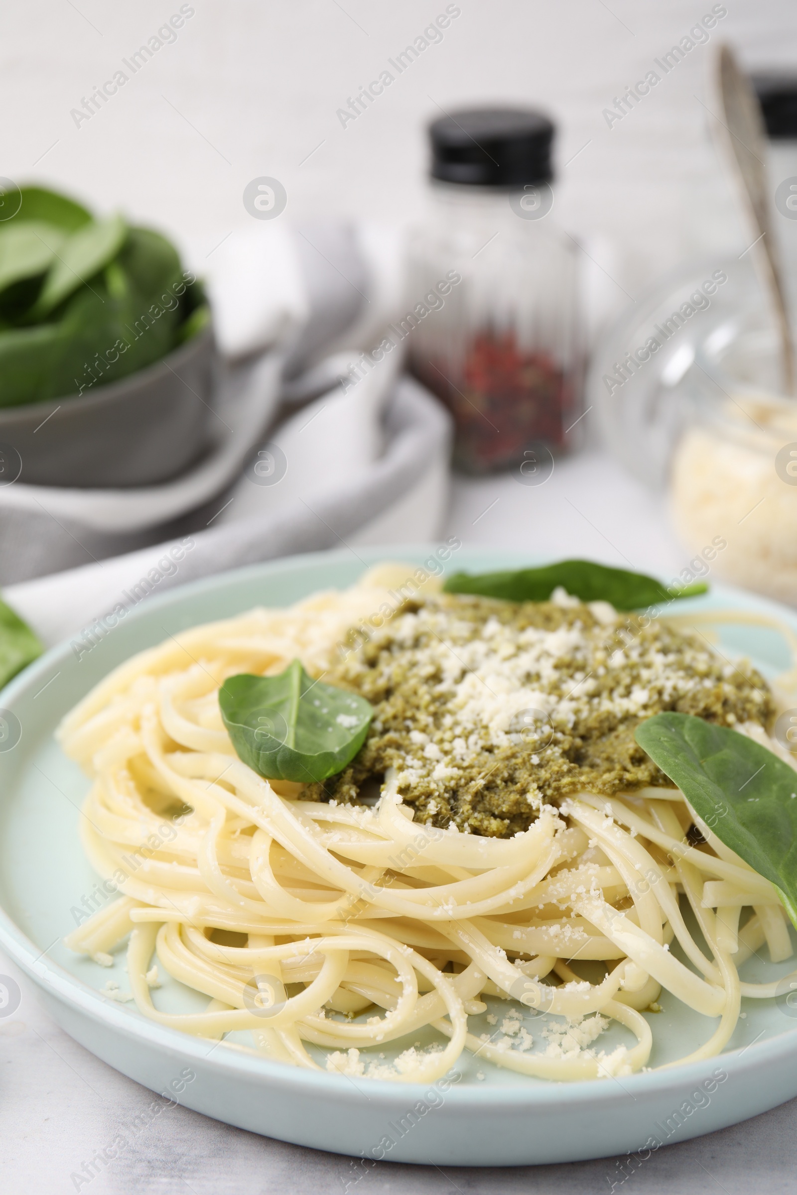 Photo of Tasty pasta with spinach, cheese and sauce on white marble table, closeup