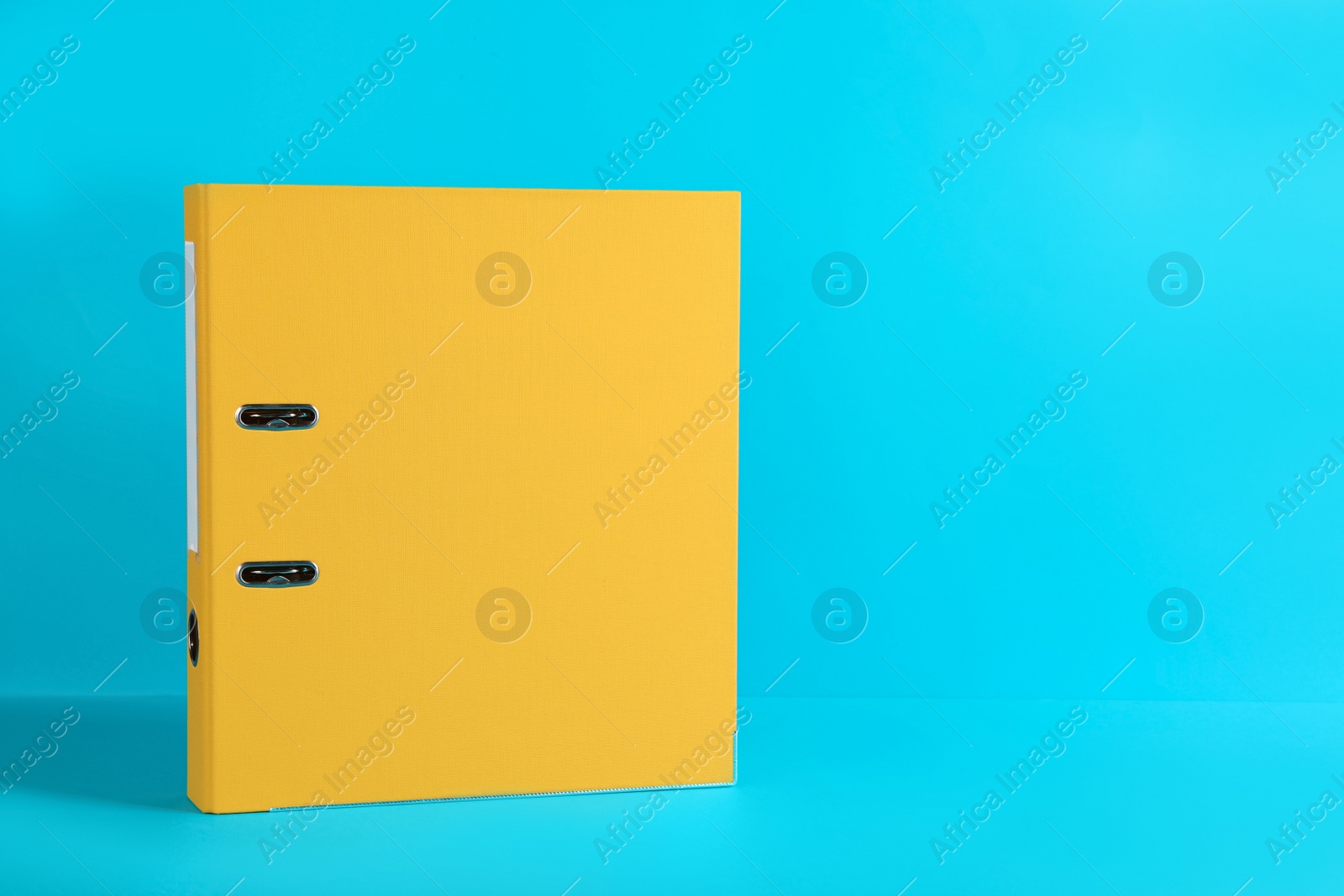 Photo of Yellow office folder on light blue background, space for text