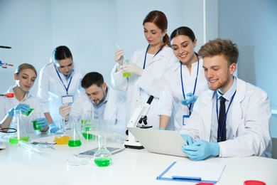 Photo of Group of scientists working in modern chemistry laboratory