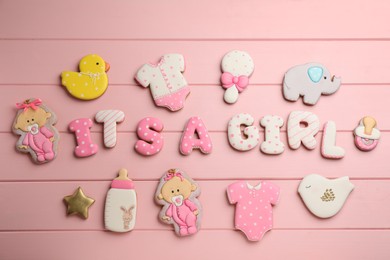 Baby shower party. Phrase It's A Girl made of cookies on pink wooden background, flat lay