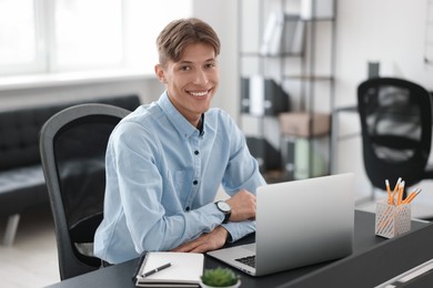 Photo of Man watching webinar at table in office