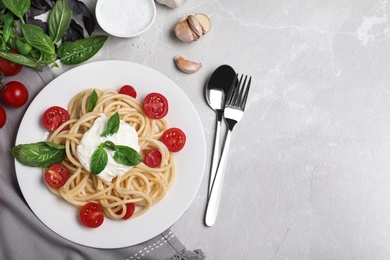 Photo of Delicious spaghetti with sour cream served on light grey marble table, flat lay. Space for text