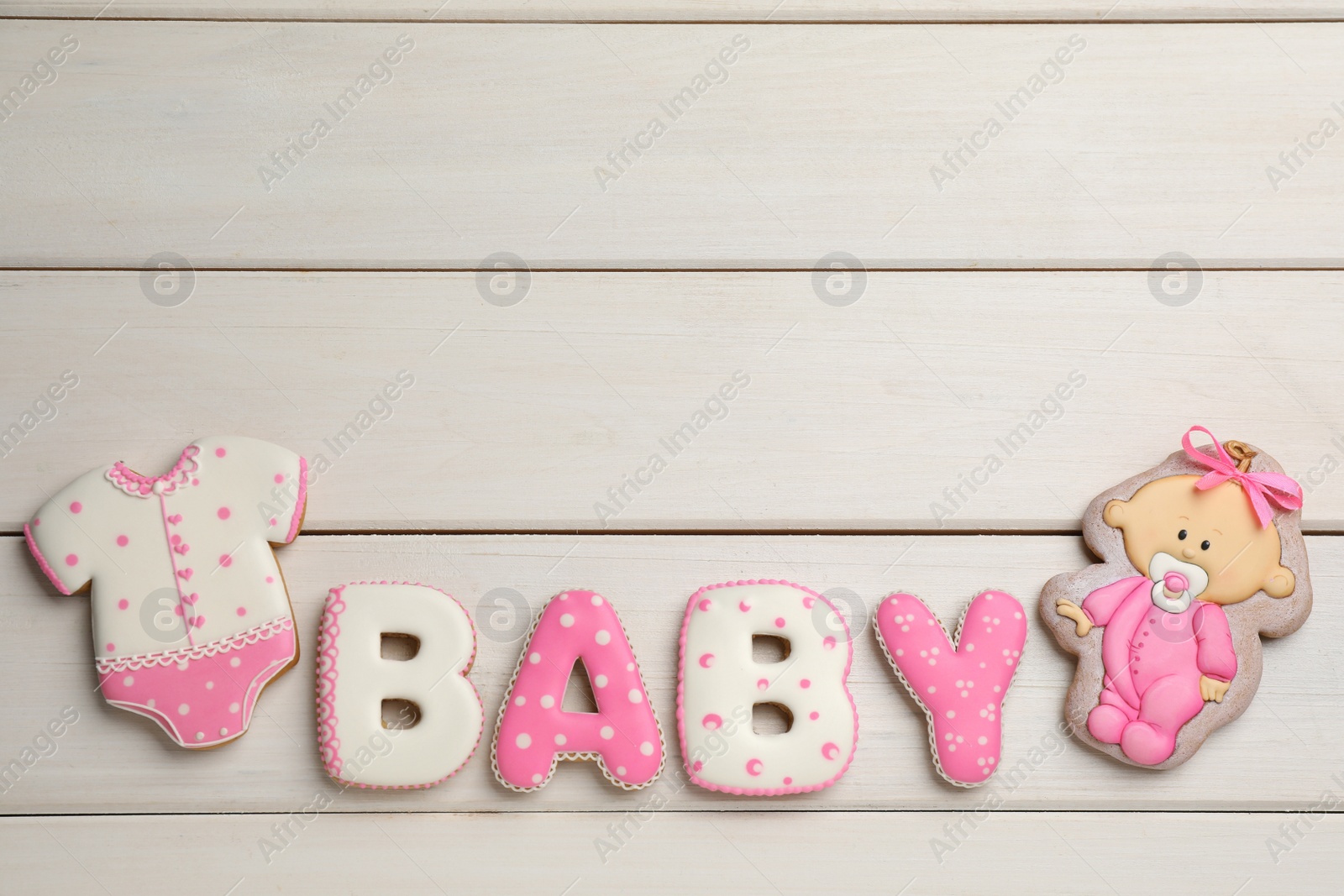 Photo of Word BABY made of tasty cookies on white wooden table, flat lay. Space for text