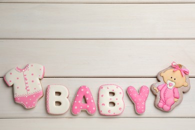 Word BABY made of tasty cookies on white wooden table, flat lay. Space for text