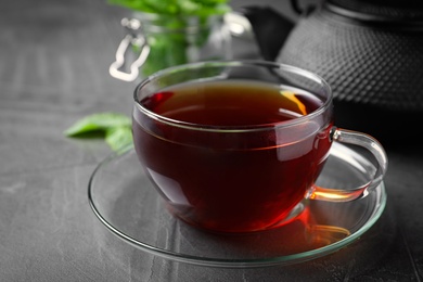 Photo of Fresh tea with mint on grey table, closeup