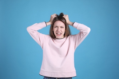 Photo of Portrait of stressed young woman on light blue background