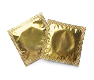 Golden condom packages on white background, top view. Safe sex