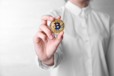 Photo of Young woman holding bitcoin on white background, closeup