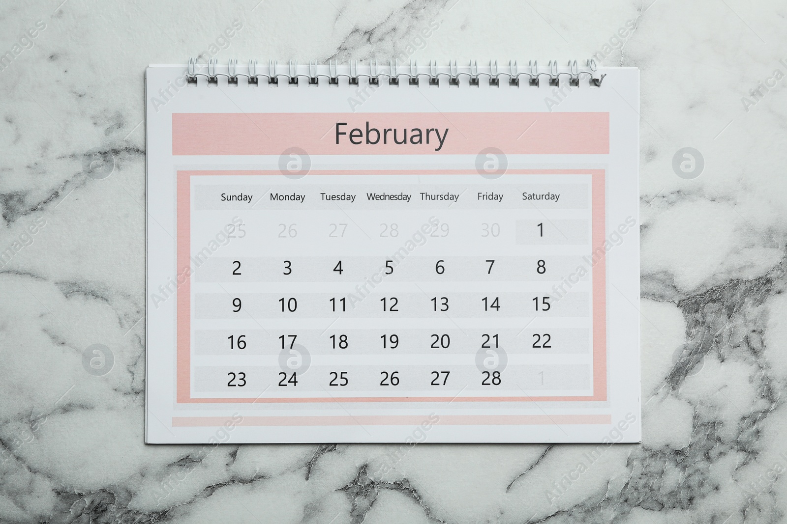 Photo of February calendar on marble background, top view