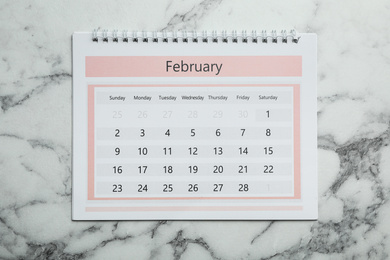 Photo of February calendar on marble background, top view