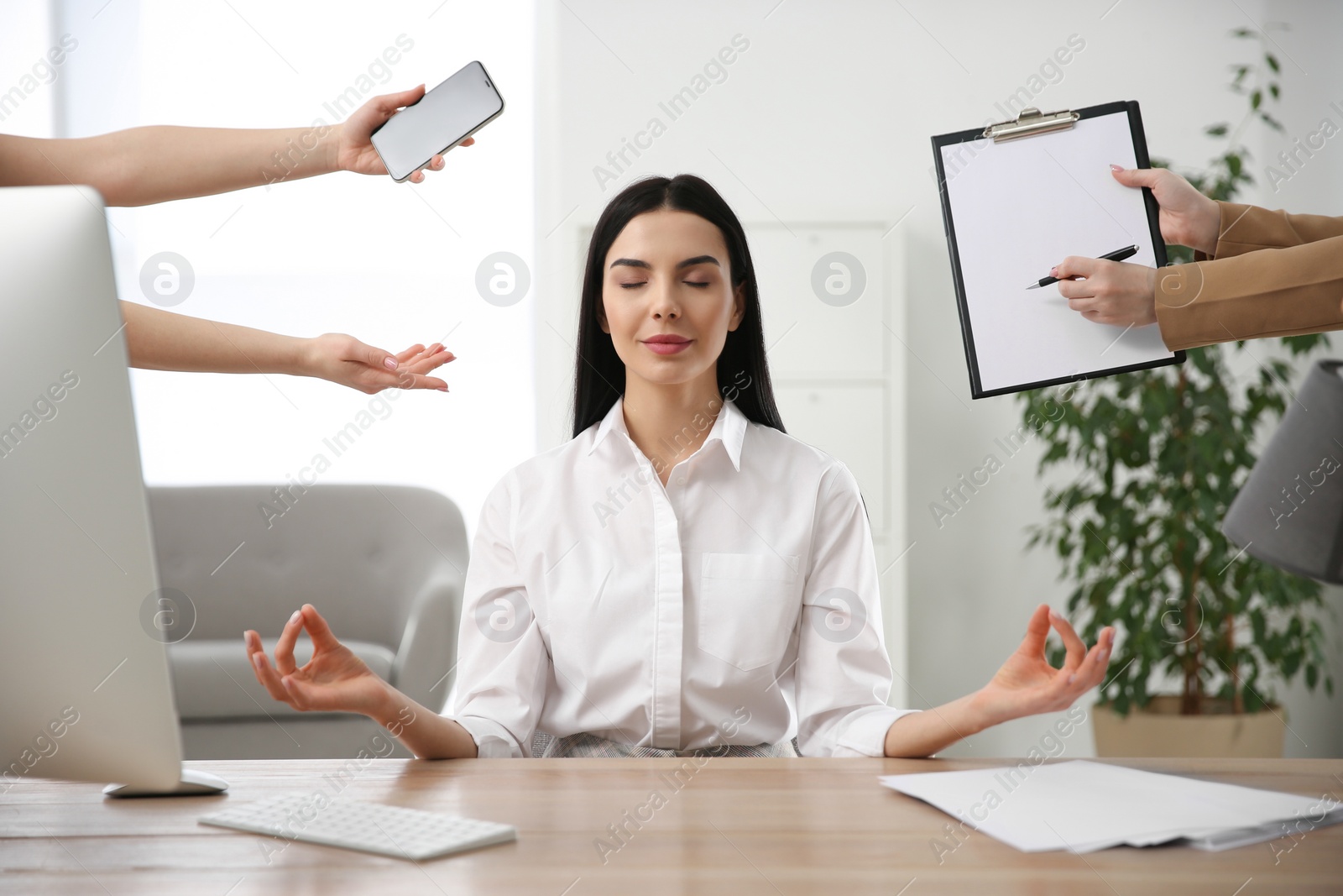 Photo of Overwhelmed woman meditating at workplace. Stress relief exercise