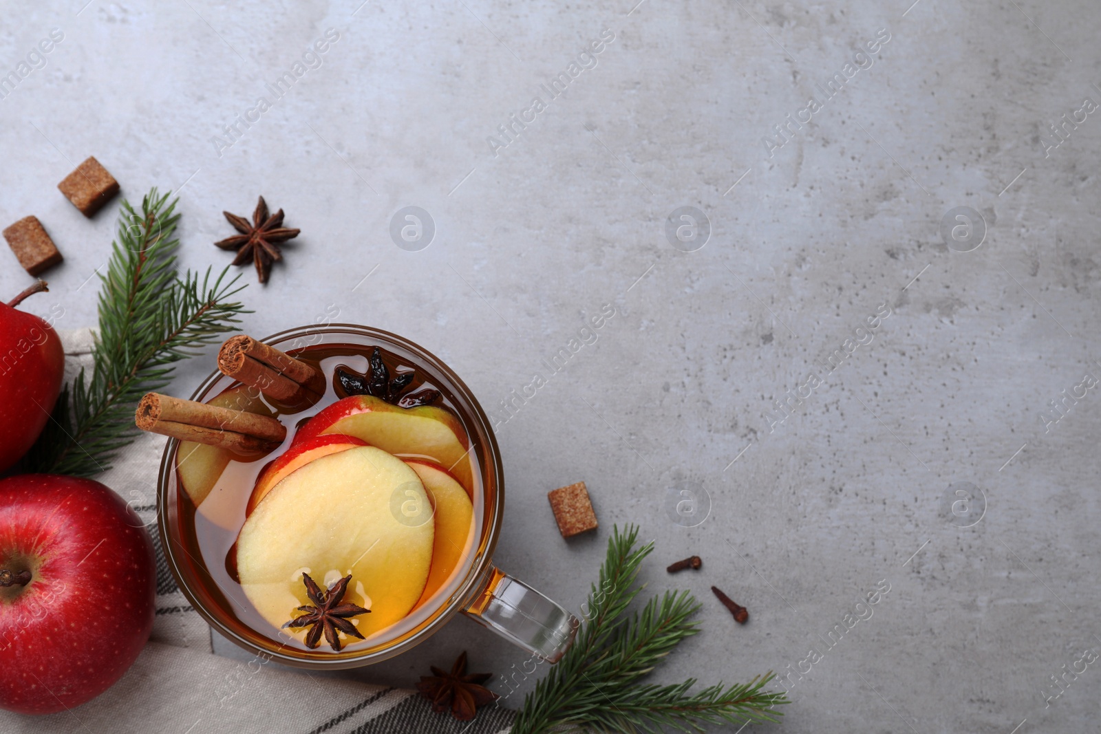 Photo of Aromatic hot mulled cider on grey table, flat lay. Space for text