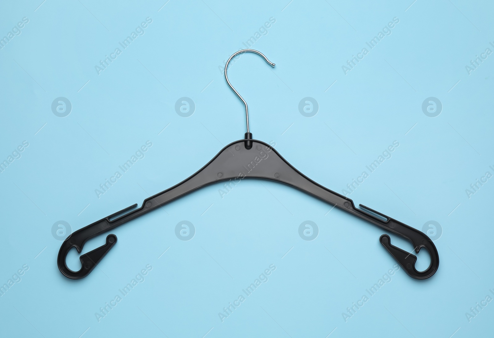 Photo of Empty hanger on light blue background, top view