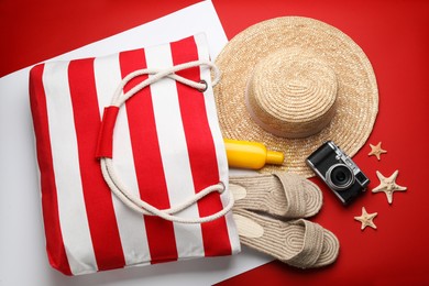 Photo of Stylish bag with beach accessories on color background, flat lay