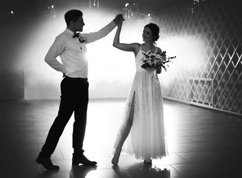 Image of Happy newlywed couple dancing together in festive hall