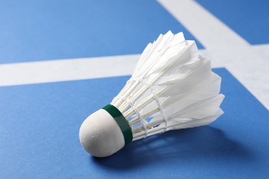 Photo of Feather badminton shuttlecock on blue background, closeup. Space for text