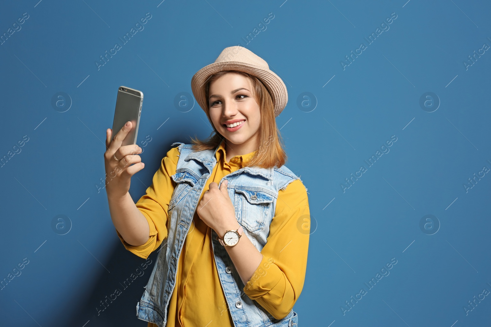 Photo of Attractive young woman taking selfie on color background