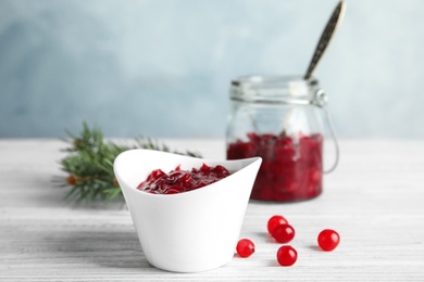 Photo of Bowl of tasty cranberry sauce on table