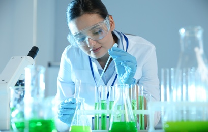 Photo of Female scientist working with sample in modern chemistry laboratory