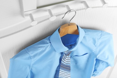 Photo of Shirt with tie on hanger indoors, above view. School uniform