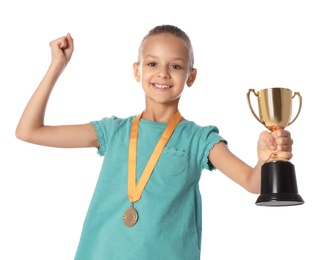 Happy girl with golden winning cup and medal on white background